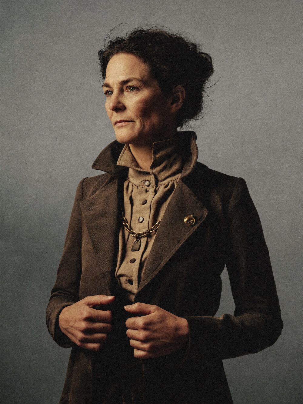 Character card: the Woman, three-quarter portrait, once-fine wool coat kept with dignity.
